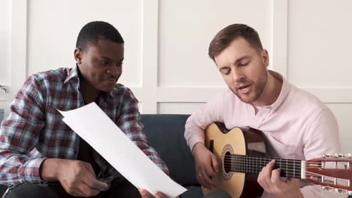 Two Men Playing Guitar and Singing Together