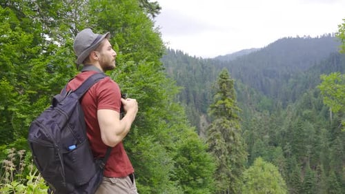 Mann beobachtet das Tal im Wald.