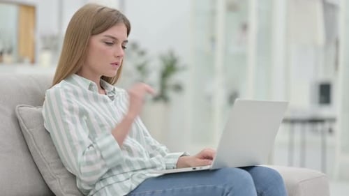 Woman Massages Stiff Neck While Using Laptop