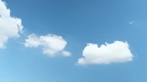 Clouds Slowly Drifting Across a Clear Blue Sky
