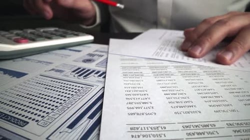 Accountant Analyzing Business Marketing Data on Paper Dashboard at Office Table