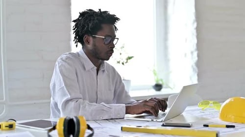 African Engineer Looking at Camera in Office