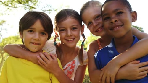 Smiling Children Hugging Together in Park Setting
