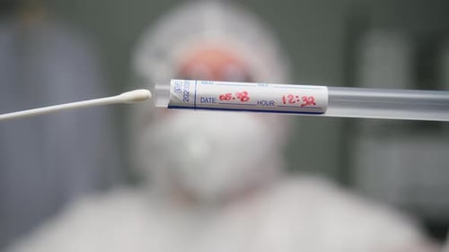 Medical Technician Removing Cotton Swab From Test Tube