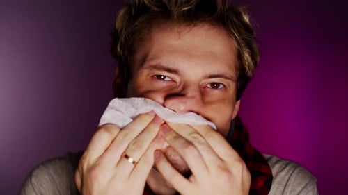 Sick Man Wipes Runny Nose with Tissue Close Up