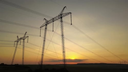 Power Lines Silhouette Against Golden Sunrise