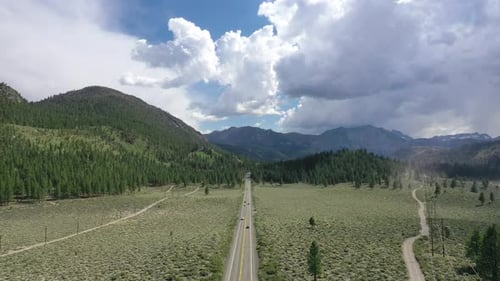 Route rurale entre de beaux champs de paysage avec des montagnes sur fond - coup de Drone aérien