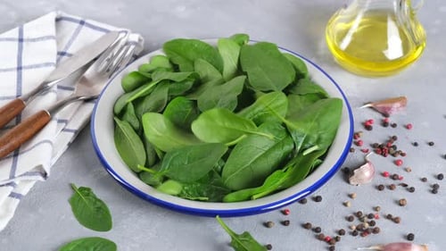 Fresh Spinach Leaves Falling into Bowl