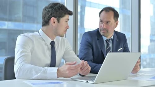 Two Colleagues Having Discussion About Laptop