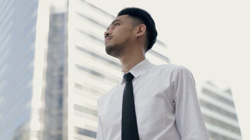 Close-up portrait of young Asian businessman in a white shirt thinking about future business.