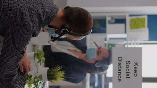 Collègues vidéo verticaux avec casque parlant dans le microphone tout en travaillant chez Financial