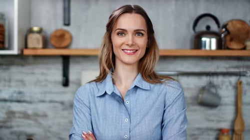 Smiling Woman in Kitchen Standing with Arms Crossed