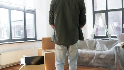 Man Unpacks Boxes in New Apartment