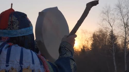 Person Holding Drum at Sunrise in Nature
