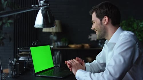 Positive Businessman Video Chatting Online on Laptop with Green Screen in Office