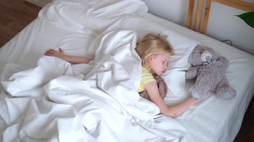 Child Sleeping in Bed with Teddy Bear