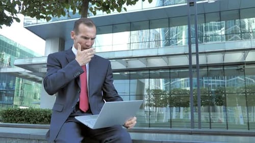 Pensive Middle Aged Businessman Sitting Outside Office
