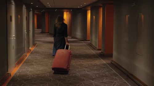- Hotel Guest with Trolley Case Walking To the Room
