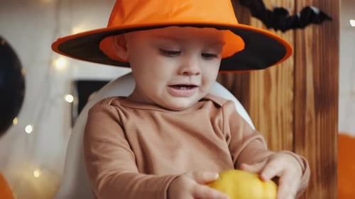 Toddler Celebrates Halloween in Costume with Pumpkin