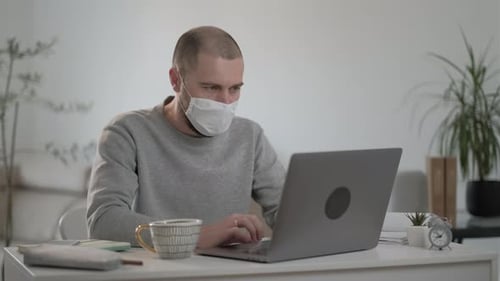 Man Working on Laptop Wearing Face Mask