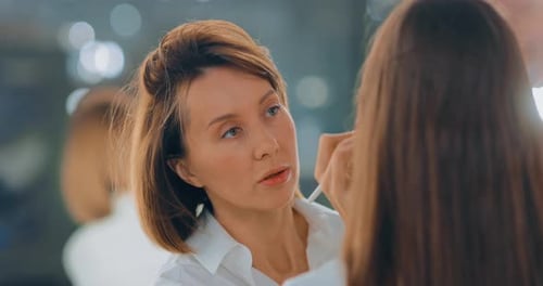 Makeup Artist Applies Brush to Woman's Face Close-up