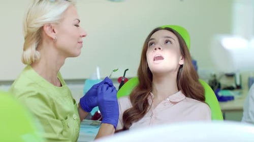 Revisión dental regular en el consultorio del dentista. Mujer feliz en sillón dental