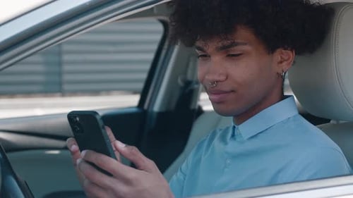 Young Adult Using Smartphone in Car