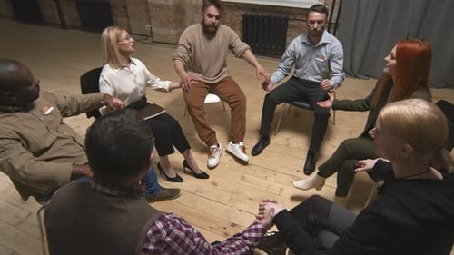Adults Holding Hands in a Group Circle Indoors