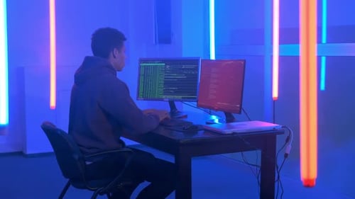 Jovem africano escrevendo programas de hackers em uma sala escura com luzes de néon