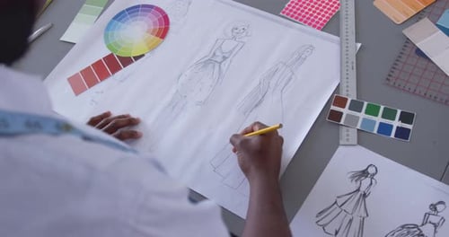 Mixed race man drawing in fashion office