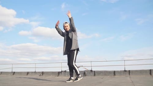 Young Adult Dances on a Rooftop