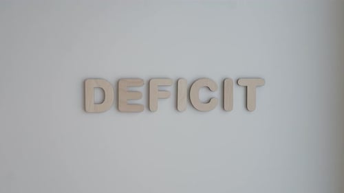 Deficit Spelled Out with Wooden Letters