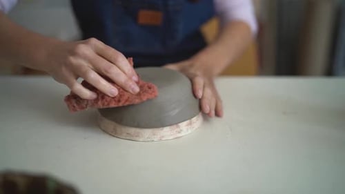Close up female potter modeling clay bowl in workshop - Artisan work and creative craft concept