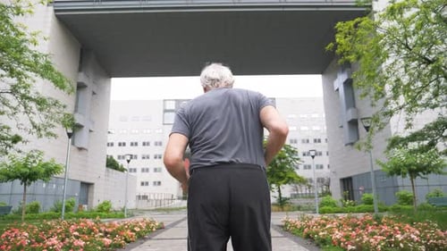 Slow motion shot of senior man jogging in city