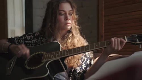 Young Woman Playing Acoustic Guitar Indoors