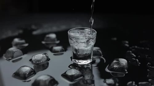 Liquid being poured into a glass with ice