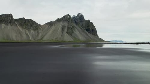Drone Over Wet Black Sand Beach Towards Vestrahorn Mountain