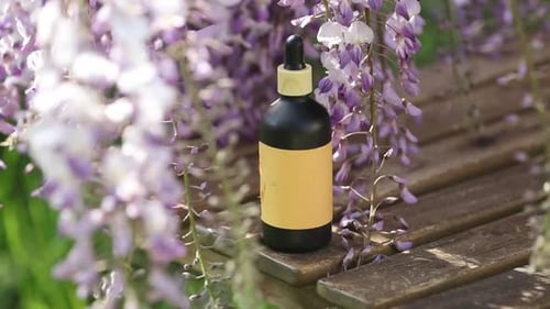 Cosmetic bottle with liquid on brown cloth and wooden table