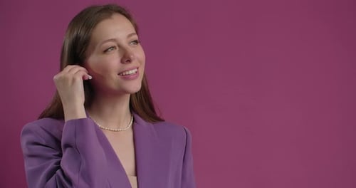 Stylish Woman Puts in Wireless Earbud, Smiles