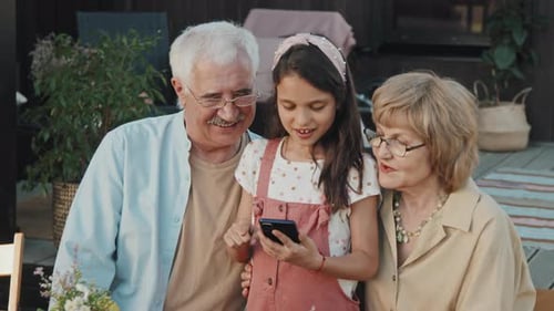 Grandparents look at phone with grandchild