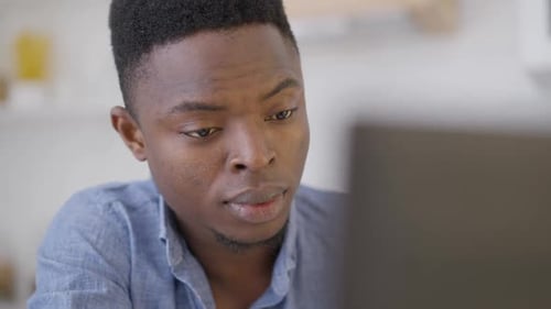 Headshot of Tired Young Handsome Man Rubbing Eyes in Slow Motion Sitting with Laptop in Home Office