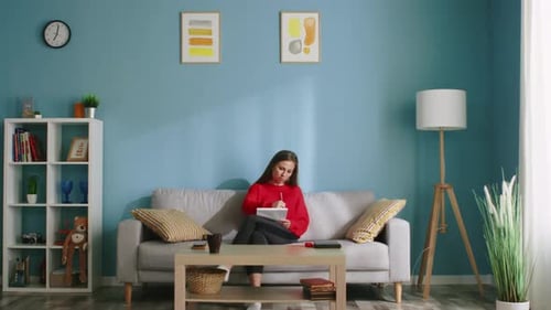 Woman Using Tablet on Sofa at Home