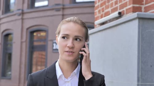 Businesswoman on Phone Walking in Urban Environment