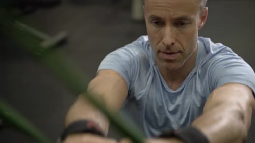 Close up image of man doing exercise with elastic band at the gym.