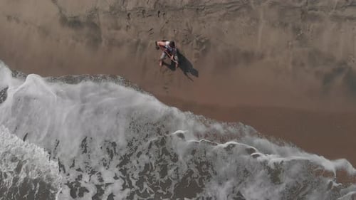 Overhead shot of a man playing guitar on the beach