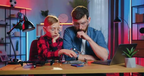 Father and Son Repairing Drone Together at Home