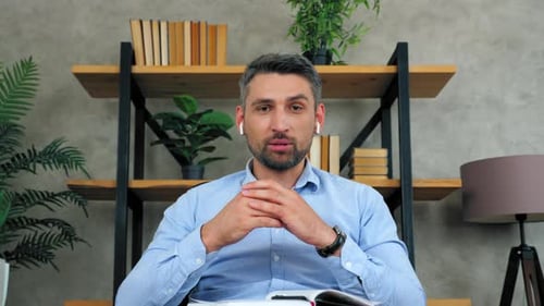 Man teacher looks camera teaches tells student video conference call chat webcam view laptop