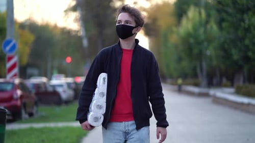 Adult Walks with Toilet Paper Outdoors Wearing Mask