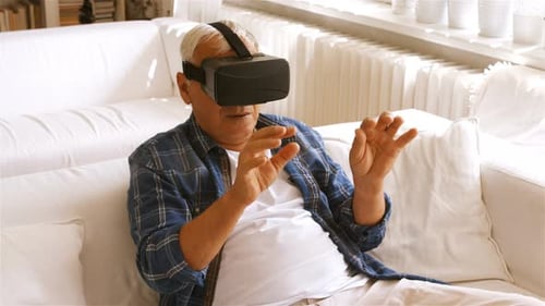 Senior Man Using Virtual Reality Headset at Home