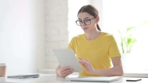 Woman Celebrating Success on Tablet in Office